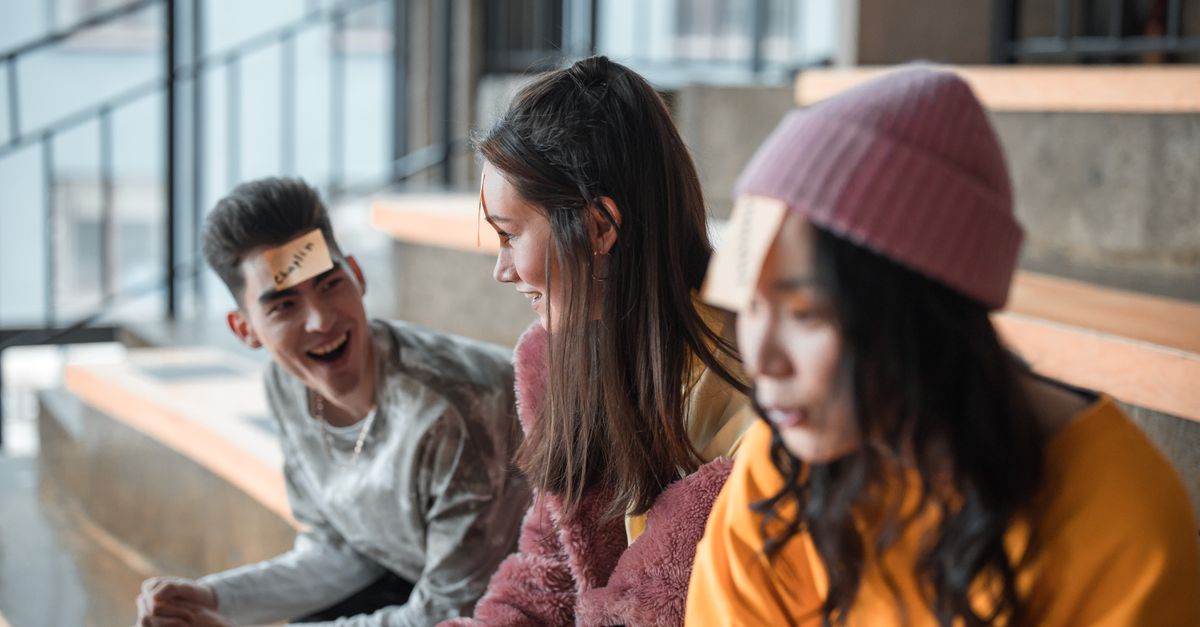 A cheerful group of young friends playing a game indoors, laughing and having fun.